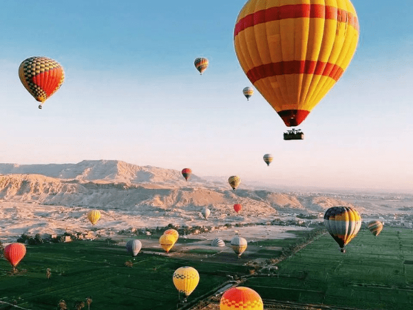 Hot air balloons over Luxor West Bank at sunrise